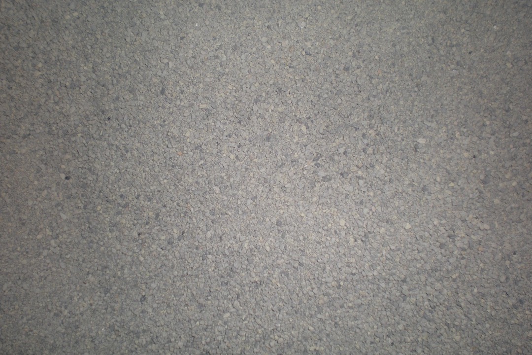 A gray tabby cat stepping into a clean litter box filled with fresh clumping litter